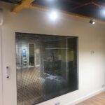 Persiana vertical em alumínio da Estrela Persianas em uma sala moderna com vista para a cidade de Santos